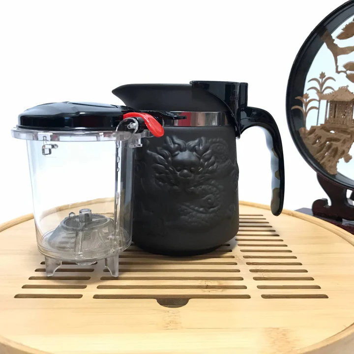 Black ceramic brewing mug with raised dragon relief and a clear infuser basket