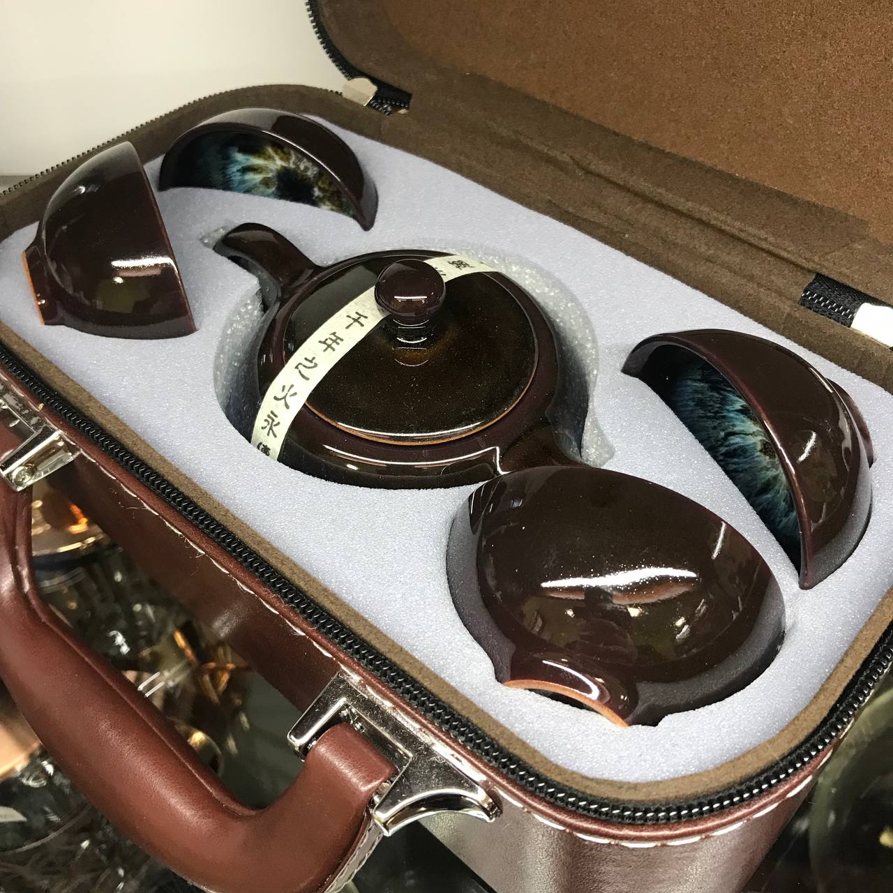 Glazed travel tea set with pot and cups packed in a fitted leather case
