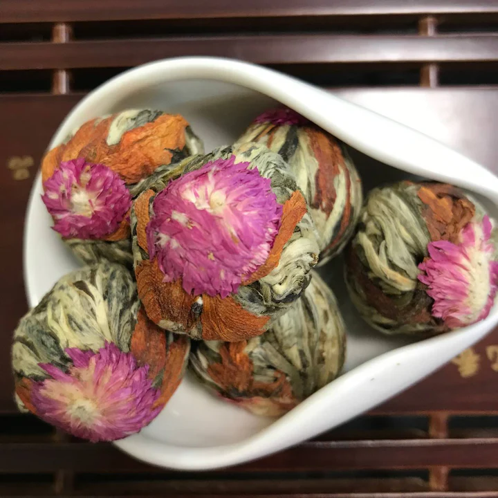 Pink and green hand-rolled blooming tea shaped like buds